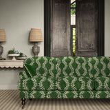 Sofa upholstered in a printed velvet fabric in green and blue featuring a stylized fern pattern.