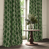 Curtains in a printed velvet fabric in green and blue featuring a stylized fern pattern.