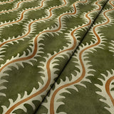 A printed velvet fabric sample in green and orange featuring a stylized fern pattern.