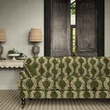 Sofa upholstered in a printed velvet fabric in green and orange featuring a stylized fern pattern.