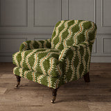 Armchair upholstered in a printed velvet fabric in green and orange featuring a stylized fern pattern.