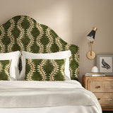 Headboard upholstered in a printed velvet fabric in green and orange featuring a stylized fern pattern.