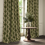 Curtains in a printed velvet fabric in green and orange featuring a stylized fern pattern.