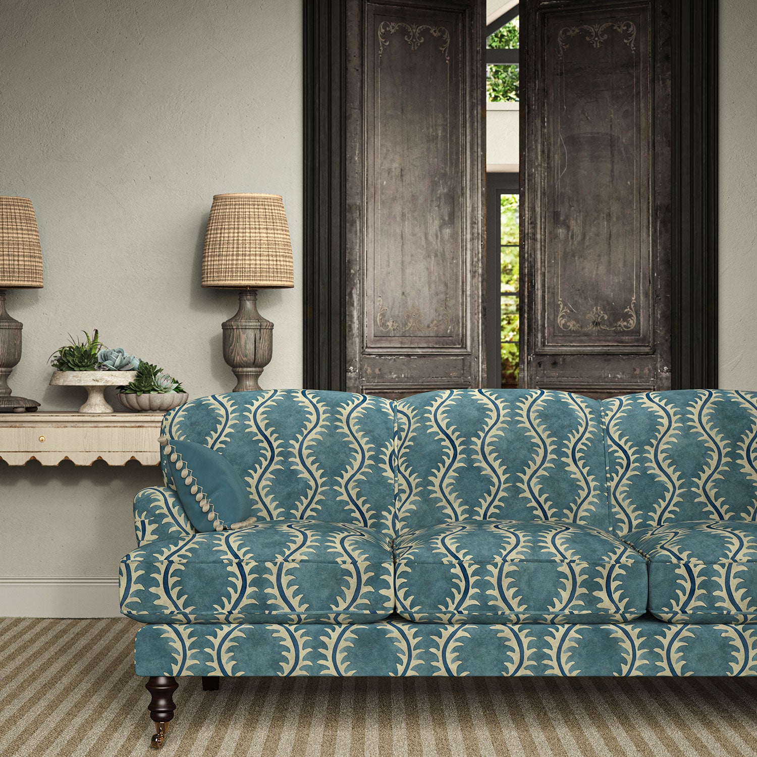 Sofa upholstered in a printed velvet fabric in blue and off white featuring a stylized fern pattern.