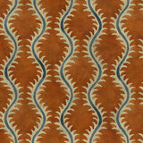 A printed velvet fabric sample in orange and blue featuring a stylized fern pattern.