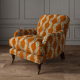 Armchair upholstered in a printed velvet fabric in orange and blue featuring a stylized fern pattern.