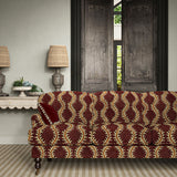 Sofa upholstered in a printed velvet fabric in purple and orange featuring a stylized fern pattern.