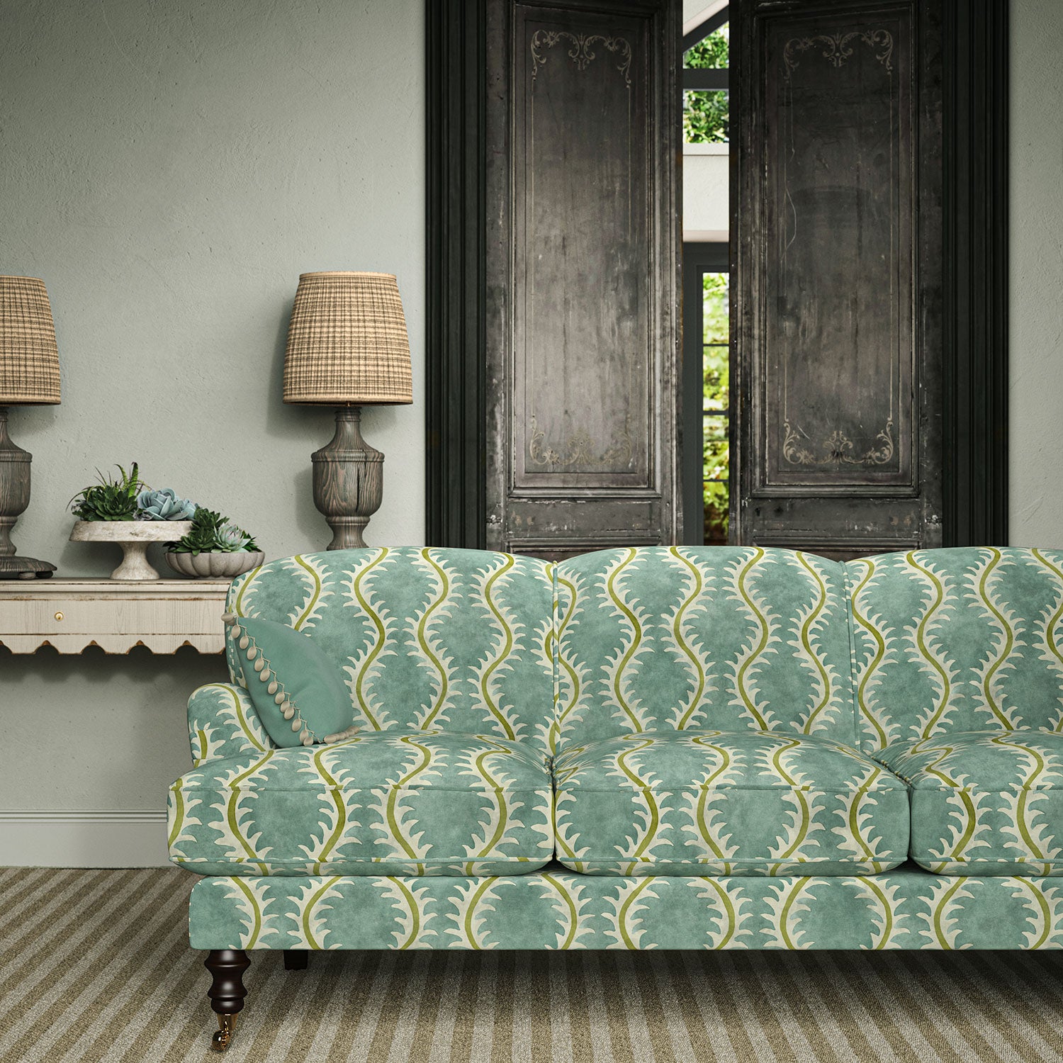 Sofa upholstered in a printed velvet fabric in blue and green featuring a stylized fern pattern.