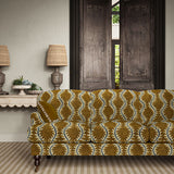 Sofa upholstered in a printed velvet fabric in brown and blue featuring a stylized fern pattern.