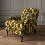 Armchair upholstered in a printed velvet fabric in brown and green featuring a stylized fern pattern.