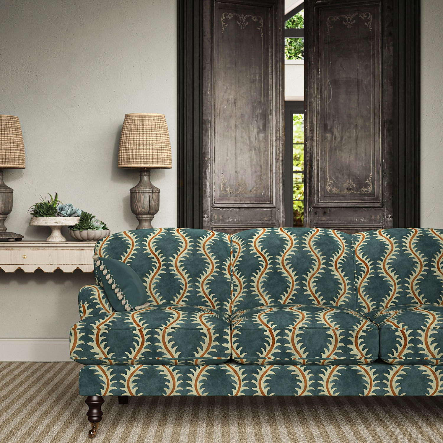 Sofa upholstered in a printed velvet fabric in blue and orange featuring a stylized fern pattern.