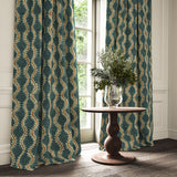 Curtains in a printed velvet fabric in blue and orange featuring a stylized fern pattern.