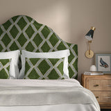 Bedroom with a curved upholstered headboard covered in green and blue printed velvet featuring an irregular diamond motif.