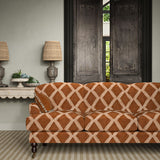 Sofa upholstered in ginger/brown printed velvet featuring an irregular diamond motif, styled in a timeless living room.