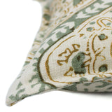 A green, cream and brown linen cushion with a central motif pattern.