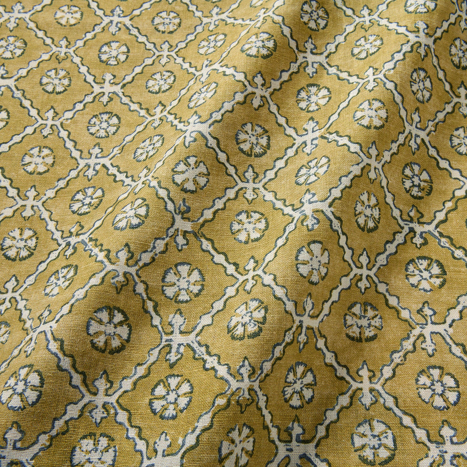 Linen fabric with a hand block-style pattern in yellow, black and cream