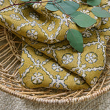 Linen fabric with a hand block-style pattern in yellow, black and cream