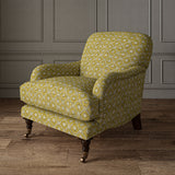 Armchair covered in a linen fabric with a hand block-style pattern in yellow, black and cream