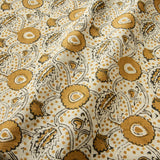 A stylised floral printed on linen fabric in orange, black and cream