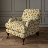 Armchair covered with a stylised floral printed on linen fabric in orange, black and cream