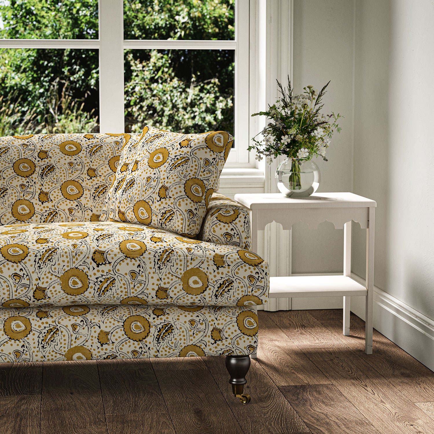 Sofa covered with a stylised floral printed on linen fabric in orange, black and cream