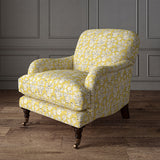 Armchair covered in a jolly printed linen fabric in yellow, black and cream