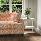 Sofa covered in a jolly printed linen fabric in orange, blue and cream