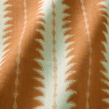 A printed linen fabric sample in orange and off white featuring a striped fern design.