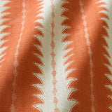 A printed linen fabric sample in orange and off white featuring a striped fern design.