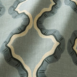 A printed linen fabric sample in blue, black, and off white featuring a mirrored ribbon pattern.