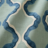 A printed linen fabric sample in blue and off white featuring a mirrored ribbon pattern.