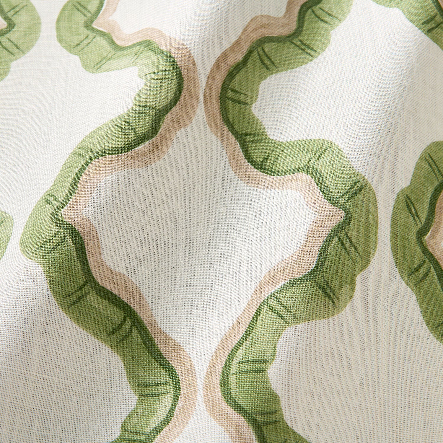 A printed linen fabric sample in green, brown, and off white featuring a mirrored ribbon pattern.