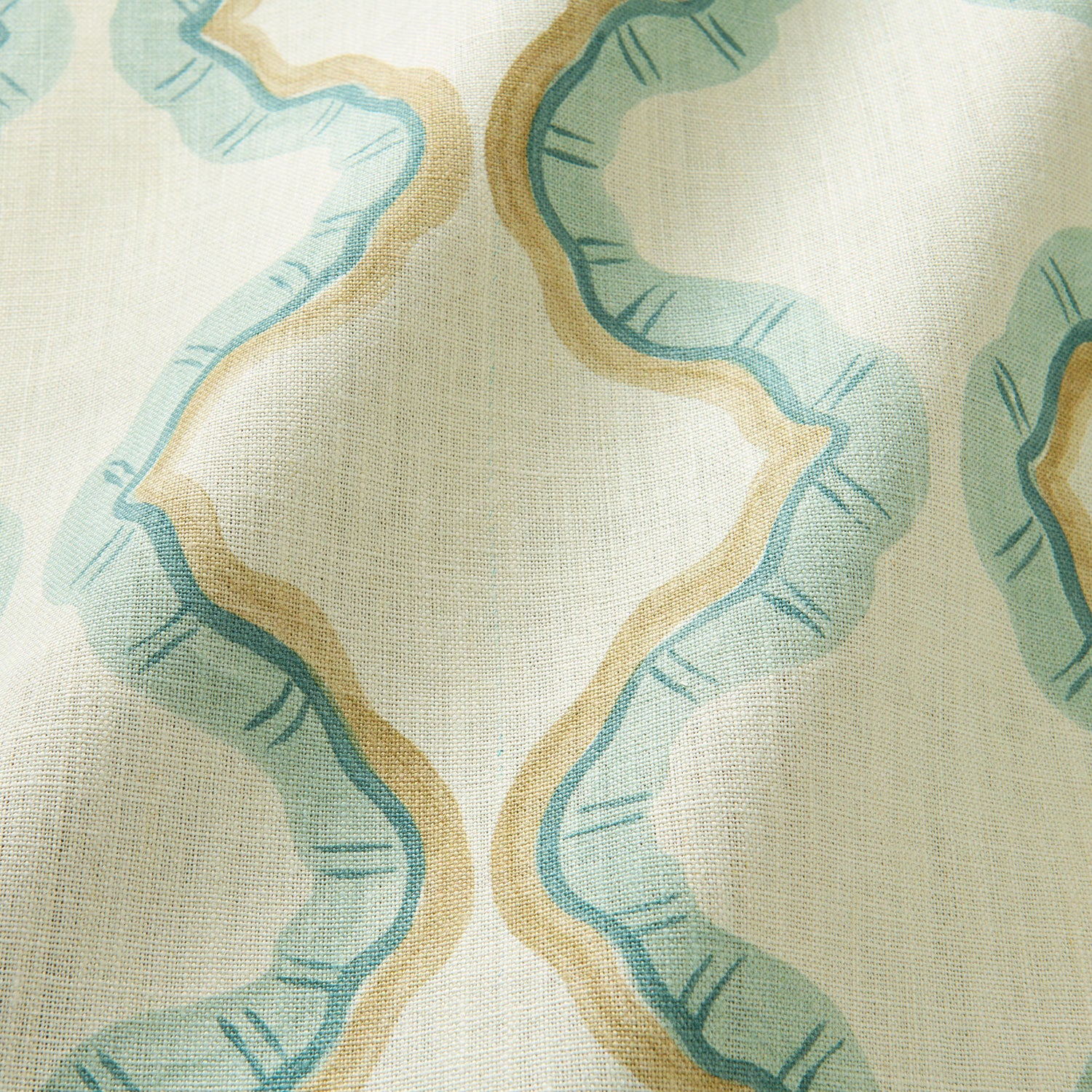 A printed linen fabric sample in blue, brown, and off white featuring a mirrored ribbon pattern.