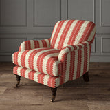 Armchair upholstered in a printed linen fabric in red and off white, featuring a striped fern design.