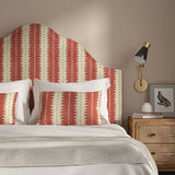 Headboard upholstered in a printed linen fabric in red and off white, featuring a striped fern design.