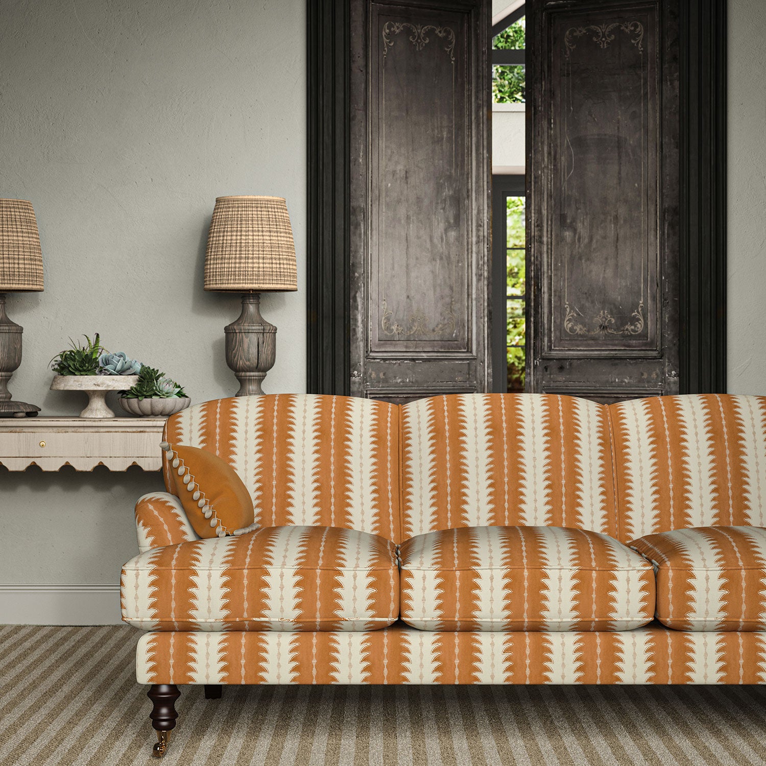 Sofa upholstered in a printed linen fabric in orange and off white, featuring a striped fern design.