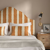 Headboard upholstered in a printed linen fabric in orange and off white, featuring a striped fern design.