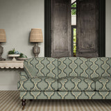 Sofa upholstered in a printed linen fabric in blue, black, and off white featuring a mirrored ribbon pattern.