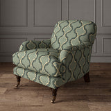 Armchair upholstered in a printed linen fabric in blue, black, and off white featuring a mirrored ribbon pattern.