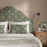 Headboard upholstered in a printed linen fabric in blue, black, and off white featuring a mirrored ribbon pattern.