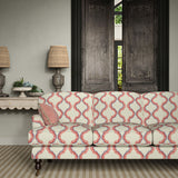 Sofa upholstered in a printed linen fabric in pink, purple, red, and off white featuring a mirrored ribbon pattern.