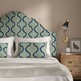 Headboard upholstered in a printed linen fabric in blue and off white featuring a mirrored ribbon pattern.
