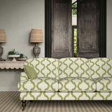 Sofa upholstered in a printed linen fabric in green, brown, and off white featuring a mirrored ribbon pattern.