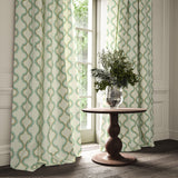 Curtains made from a printed linen fabric in blue, brown, and off white featuring a mirrored ribbon pattern.