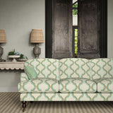 Sofa upholstered in a printed linen fabric in blue, brown, and off white featuring a mirrored ribbon pattern.