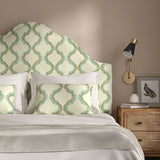Headboard upholstered in a printed linen fabric in blue, brown, and off white featuring a mirrored ribbon pattern.