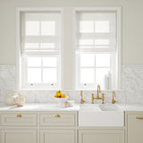 Blinds made from a printed linen fabric in blue, brown, and off white featuring a mirrored ribbon pattern.