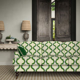 Sofa upholstered in a printed linen fabric in green, blue, and off white featuring a mirrored ribbon pattern.