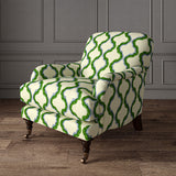 Armchair upholstered in a printed linen fabric in green, blue, and off white featuring a mirrored ribbon pattern.