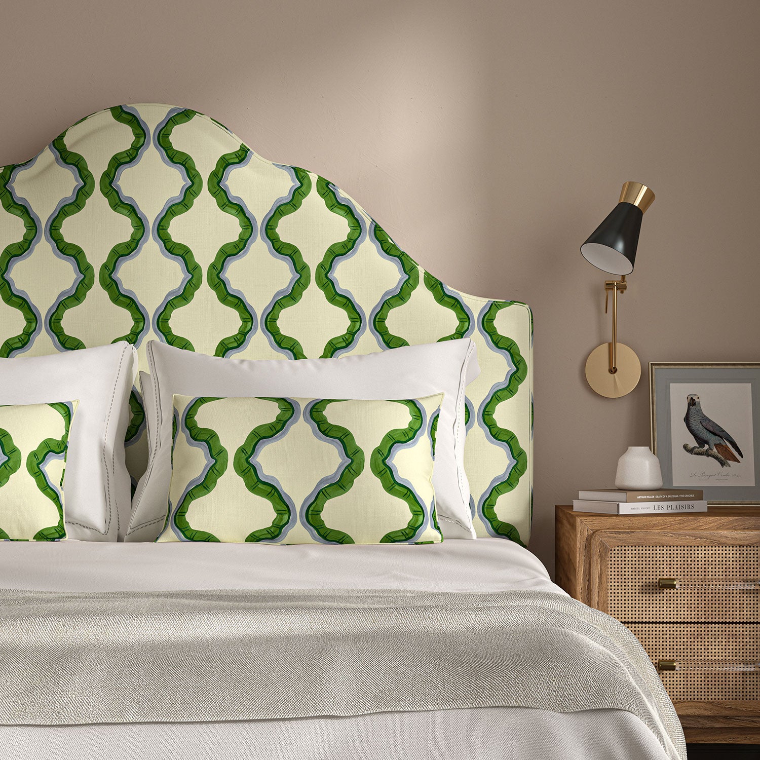 Headboard upholstered in a printed linen fabric in green, blue, and off white featuring a mirrored ribbon pattern.